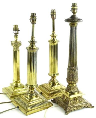 A collection of four brass column table lamps, each on a square base, the largest 54cm H.