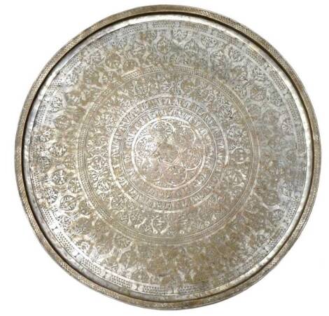 An Indian heavy brass circular tray, with silvered decoration engraved with roundels, flowers, leaves etc., 88cm dia.