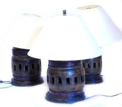 A set of three African carved hardwood table lamps, each of circular form with pierced sections to the centre, the largest 55cm H.