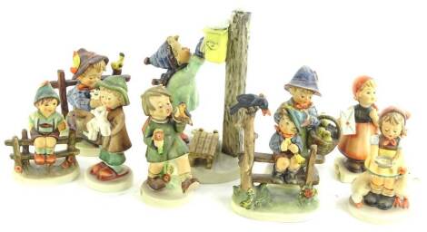 A collection of Goebel Hummel figures, to include boy on a fence, boy with a flower and bird, posting a letter etc. (9)