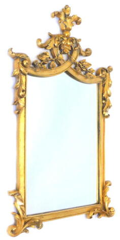 A gilt wall mirror, the frame decorated with leaves, scrolls etc., 99cm H, 60cm W.