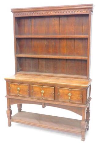 A 20thC oak dresser, the raised back with three plate shelves, the base with three panelled frieze drawers, on block feet, with an under tier, 137cm W.