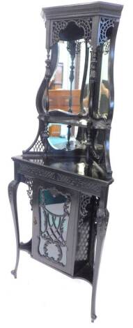 An Edwardian ebonised mahogany corner cabinet, the raised back with two cartouche shaped bevelled mirror plates, on turned supports, the base with a glazed door, flanked by two recesses on scroll carved cabriole legs, 187cm H, 72cm W.