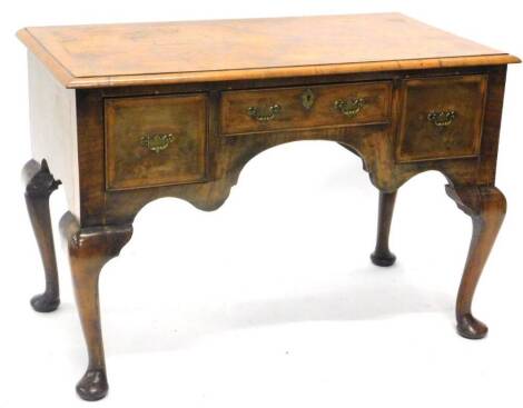 A burr walnut and walnut lowboy in mid 18thC style, the rectangular quarter veneered top with a cross and feather band and a moulded edge above a frieze drawer, flanked by two deeper drawers around a shaped apron on cabriole legs with pad feet, 106cm W.