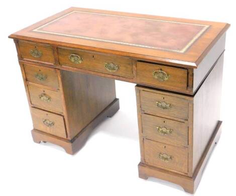 An early 20thC oak pedestal desk, the rectangular top with a later leatherette inset above an arrangement of nine drawers on bracket feet, 106cm W.