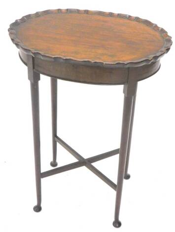 A mahogany occasional table, the oval top with a pie crust border on turned legs with pad feet, 50cm W.