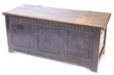 A late 17th/early 18thC oak coffer, the associated rectangular top with a carved border, above a frieze carved with flutes and three panels carved with squares and fans, on stiles, 131cm W.