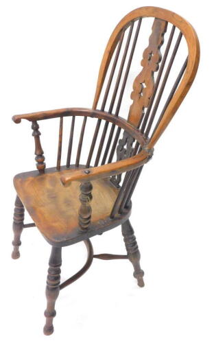 A mid 19thC yew, ash and elm Windsor chair, with a pierced splat, spindle turned supports and solid seat, with turned legs and crinoline stretcher.