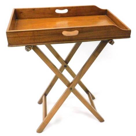 An Edwardian mahogany butler's tray, the rectangular tray with side handles on X shaped folding base, 70cm W.