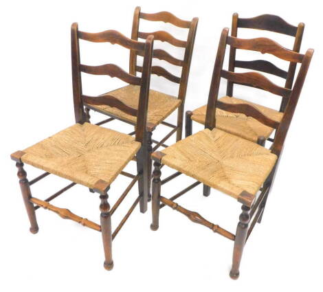 An associated set of four 19thC country made oak and ash ladder back chairs, each with a rush seat on turned legs. Provenance: The property of Joan Stephenson, Kirkwood, North Church Walk, Newark, Nottinghamshire.