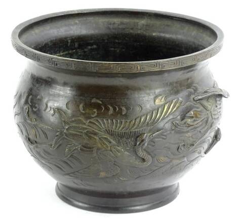 A late 19th/early 20thC oriental bronze jardiniere, decorated with flying storks, the underside signed and cast with mythical beasts, trees, storks etc. 25cm dia.