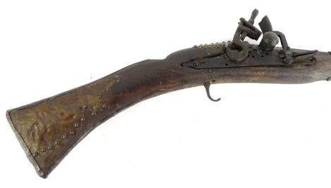 A Middle Eastern rifle, with embossed brass mounts, 153cm L.