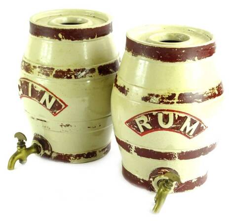 A pair of 19thC stoneware spirit barrels, for rum and gin, each with a brass tap, decoration (AF), 27cm H.