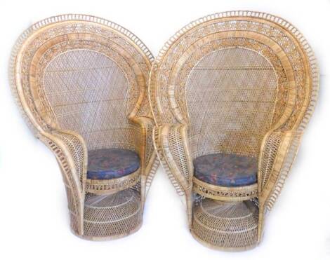 A pair of rattan conservatory peacock design chairs, each with a fan shaped back and a padded seat.