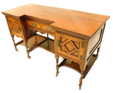 A Victorian aesthetic movement dressing table, the inverted bow front top above a burr veneered drawer, flanked by similar panelled doors, above a shaped undertier on reeded and turned legs with ceramic castors, in the manner of Lamb of Manchester, 73cm H