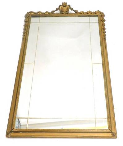 A gilt gesso wall mirror, the plate with insized decoration, the frame decorated with bell flower and a cartouche, 95cm x 53cm.