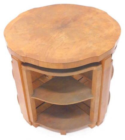 An Art Deco nest of four tables, the largest table with a shaped top and square section supports, above four corner type occasional tables, 61cm dia.