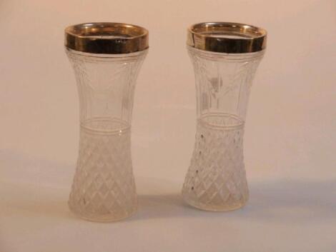 A pair of early 20thC cut glass waisted vases with silver mounts