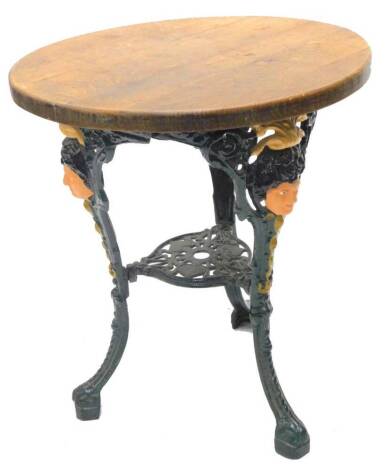 A cast iron pub table, with a circular top, the base cast with female masks, pierced scrolls etc., 60cm dia.