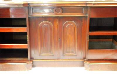 A Victorian mahogany inverted breakfront mirror back sideboard, the shaped glass surmounted by a carved scroll and shell motif, with an arrangement of further scrolls to each corner, above a canted top and four cupboards, each with arched panelled doors o - 3