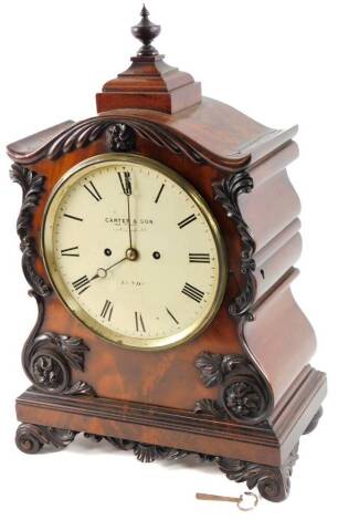 John Carter & Son Cornhill, London. An early 19thC mahogany bracket clock, with a swept case set with various scroll and floral mouldings, surmounted by an urn finial, with 21cm Dia. Roman numeric dial, signed and titled and the back plate stamped John Ca