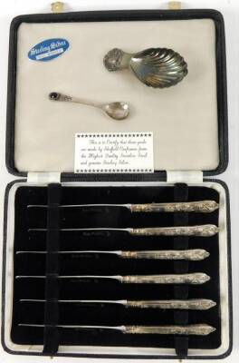 An Elizabeth II silver caddy spoon, with shell capped handle and bowl, London 1965, 7cm W, a silver teaspoon, with inset polished oval to the stem and a cased set of sterling silver entree knives, 2oz of silver. (a quantity)