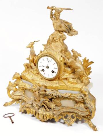 A 19thC gilt metal mantel clock, surmounted by a highland figure, flanked by dog and stag in a naturalistic setting, with 8cm white enamel Arabic dial raised on a marble plinth base, fronted by pierced shells and scrolls, dead game, dog heads, beads, flow