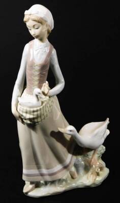 A 20thC Lladro figure, of a lady in flowing robes holding goose with further goose to her side, printed marks beneath, 32cm H.