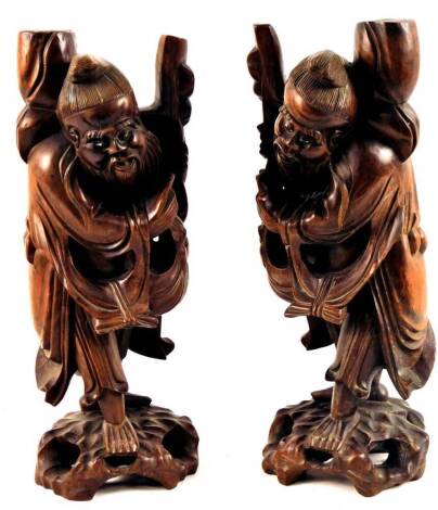 A pair of Chinese late Qing period hardwood figures of bearded sages, each in flowing robes on pierced naturalistic bases, 38cm H. (2)