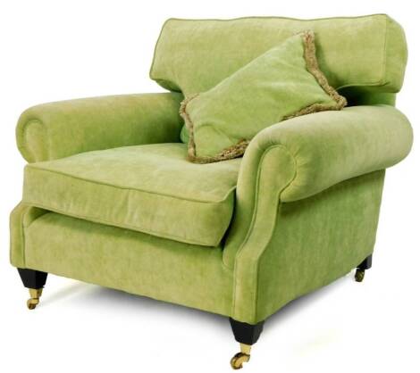 A deep seated armchair, in green material with T shaped cushion on castors, 86cm H.