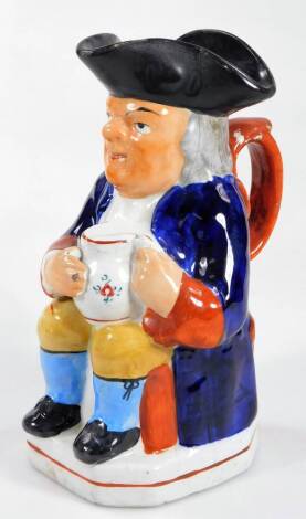 A Victorian Staffordshire pottery Toby jug, seated holding a foaming jug of ale and pipe wearing jacket, neckerchief, waistcoat and breeches, polychrome decorated, predominantly in blue, yellow and orange, 25cm H.