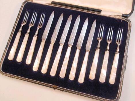 A set of silver fruit knives and forks with mother of pearl handles