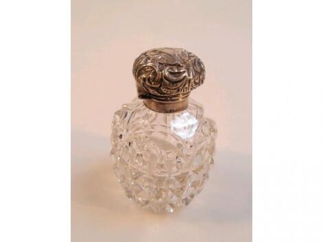 An Edwardian glass scent bottle with silver mount and emboss hinged lid