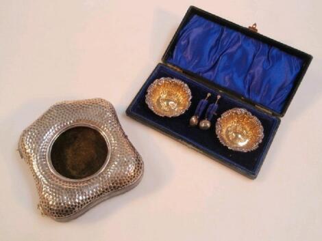 An Edwardian silver desk watch case hinged cover of beaten cushioned design