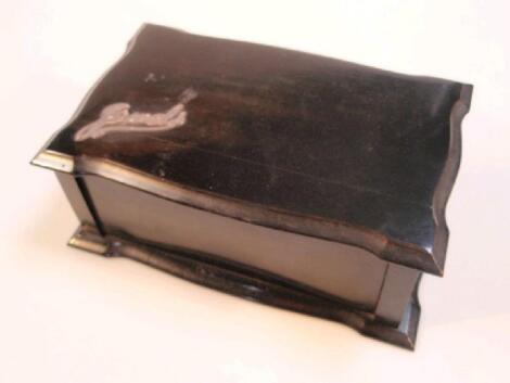 An Edwardian ebony jewel casket of shaped rectangular form the hinged lid