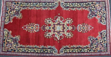 A Kerman rug, in red and cream, 225cm x 120cm.