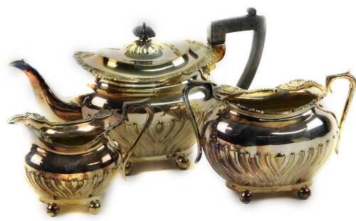 A silver plated tea set of semi fluted bombe form, with shell scroll and gadroon borders, each piece mounted on four ball feet.