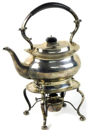 A George V silver tea kettle and burner stand, the kettle of squat baluster form, the rigid scrolled handle with ebonised insulating handle on a rectangular base with four cabriole legs on bun feet around a plain central burner, 36oz, 36cm H.