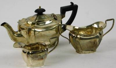 A George V silver three piece bachelor's tea service, comprising teapot 12cm H, two handled sugar bowl and milk jug, Chester 1912, 14oz all in. (3)