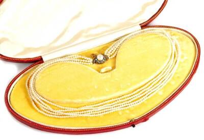 A five strand cultured pearl necklace, with circular clasp set with central cultured pearl approx 5mm W, surrounded by tiny old cut diamonds, in yellow metal, unmarked, the clasp 1.5cm W, with safety chain, 40cm L overall, 19.7g all in, boxed.