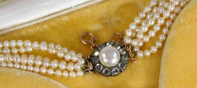 A five strand cultured pearl necklace, with circular clasp set with central cultured pearl approx 5mm W, surrounded by tiny old cut diamonds, in yellow metal, unmarked, the clasp 1.5cm W, with safety chain, 40cm L overall, 19.7g all in, boxed. - 2