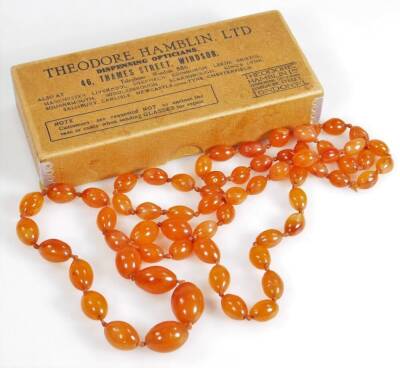 An orange agate longuard necklace, with graduated oblong beads, the largest 22mm, the smallest 14mm, on orange string strand, 55cm high overall.