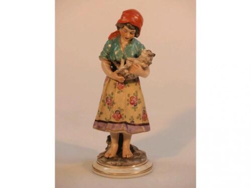 A 19thC porcelain figure of a young girl in colourful country costume with