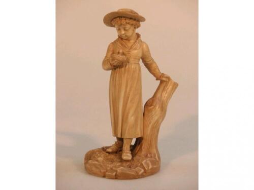 A Worcester Hadley Kate Greenaway type figure of a young girl holding a bird's nest