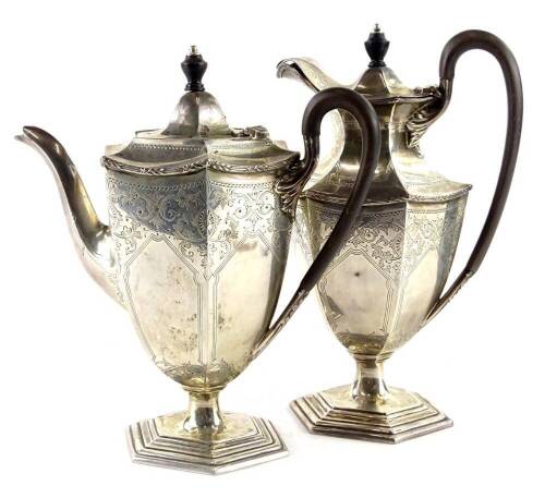 An Edwardian silver small coffee pot, of hexagonal form engraved with scrolls, cartouches etc, with ebonised knob and handle and a matching hot water jug each on a stepped foot, the coffee pot Sheffield 1905, the hot water jug date letter indistinct, 26oz