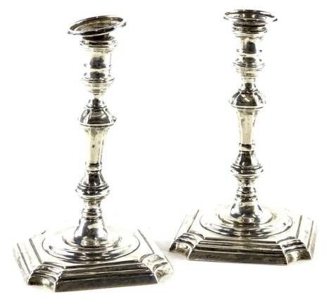 A pair of George V silver candlesticks, in mid 18thC style each with a turned column and square base with canted corners, one loaded Sheffield 1926. 7¾oz gross.