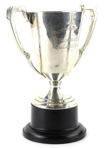 A George VI silver two handled trophy, engraved Lincoln and Lincolnshire Gardeners Association, FW Woolworth and Co Limited Challenge Cup, London 1937, 14oz, on a black Bakelite base engraved with various names.