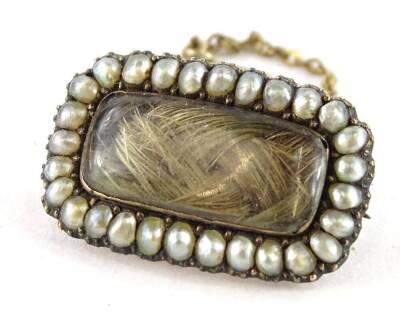 A Victorian memorial brooch, with rectangular window panel, with lockets of hair, with seed pearl surround, and safety chain, yellow metal, unmarked, 2.2cm W, 5g all in.