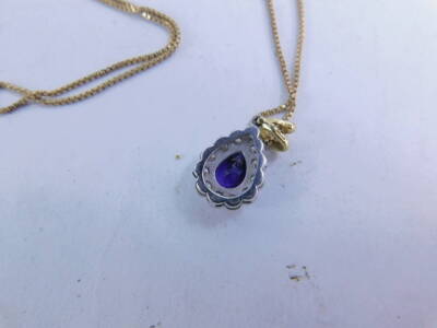 A pear shaped amethyst pendant, surrounded by diamonds, attached to a slender link necklace. - 2