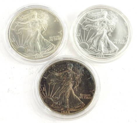 Three United States silver dollars, comprising 1993, 1995 and 1988.